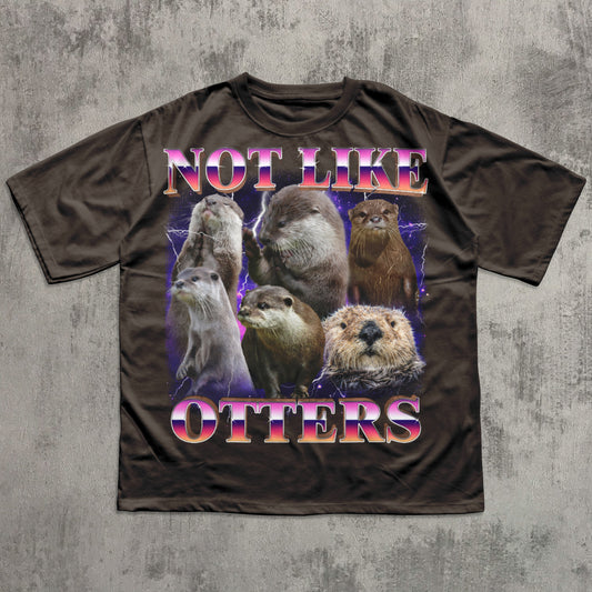 Brown t-shirt with otter graphic and text 'Not Like Otters' on a textured gray background