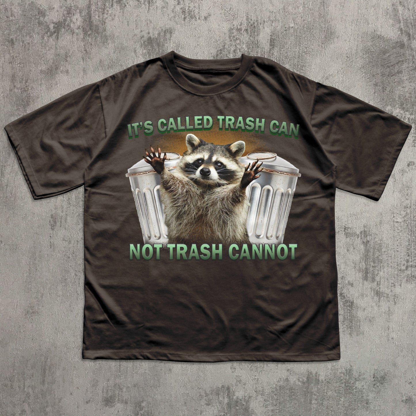 Brown t-shirt with a raccoon graphic and text on a textured gray background