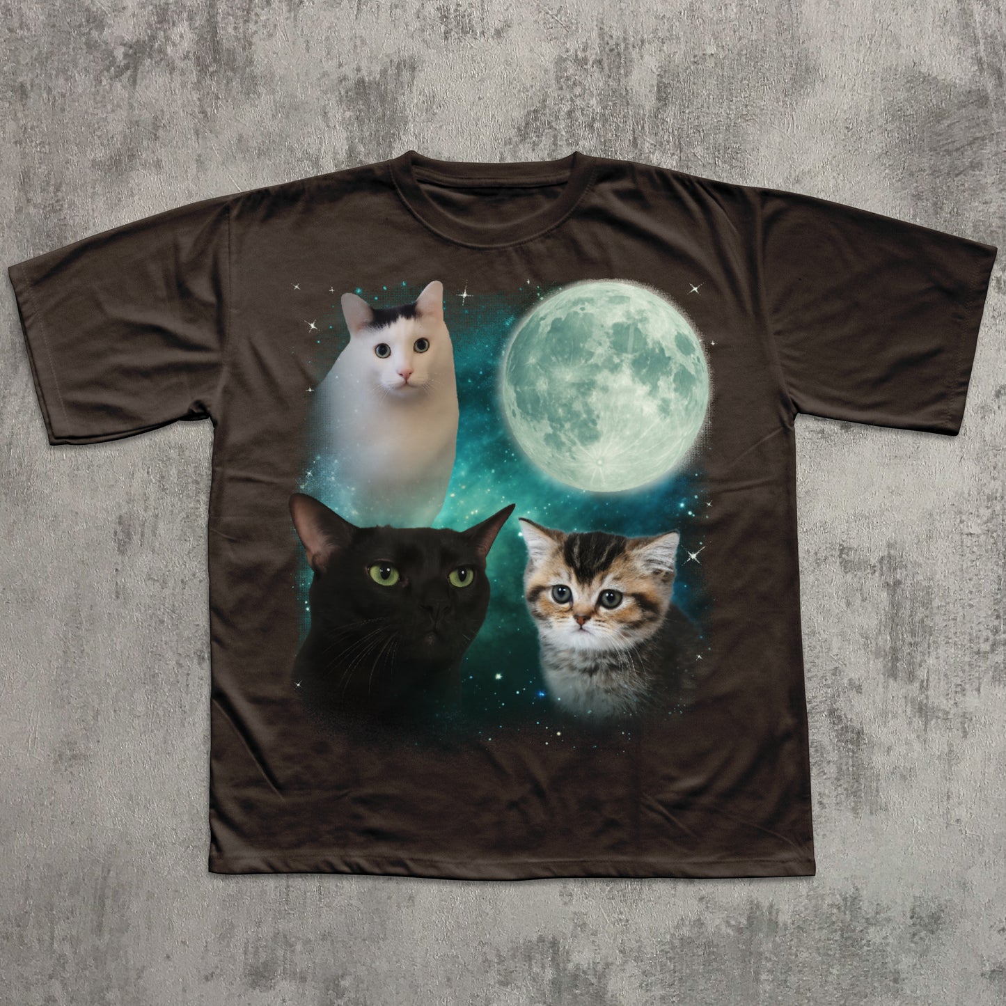 Brown t-shirt with cats and a moon graphic on a textured gray background