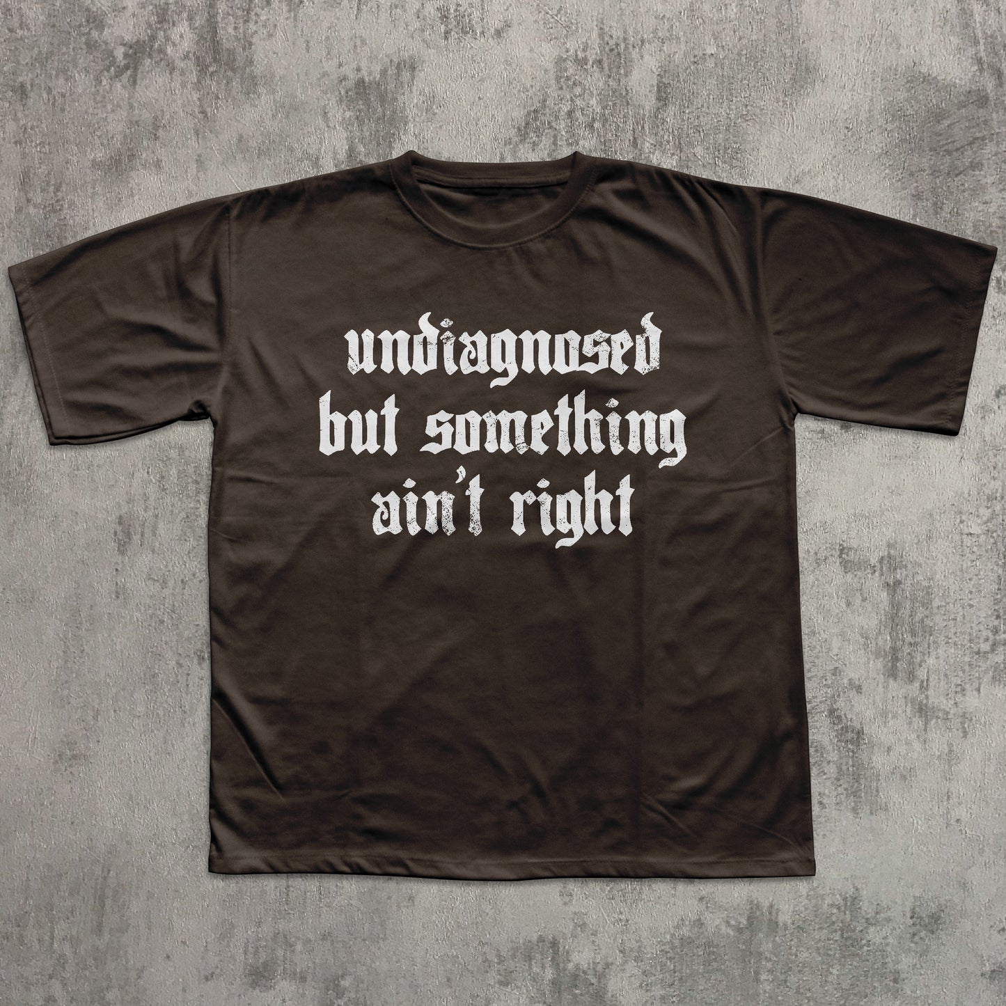 Brown t-shirt with white text on a textured gray background