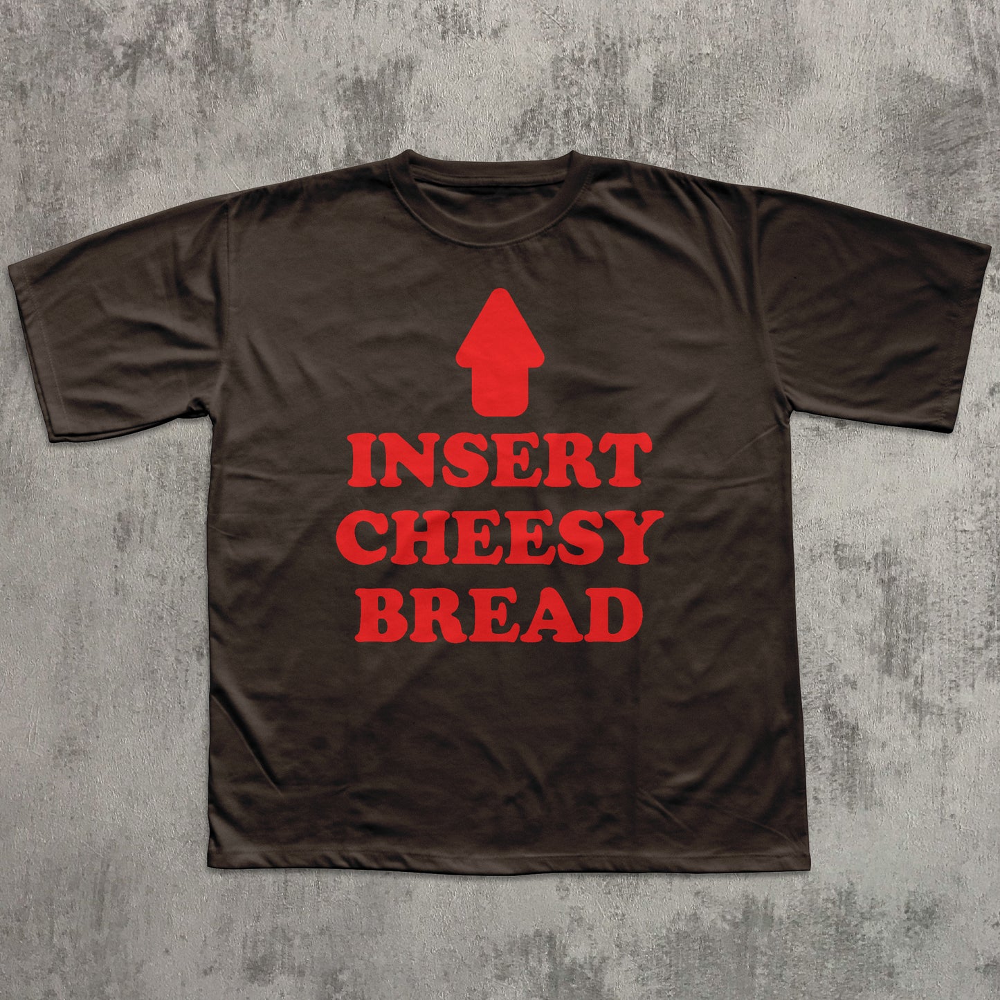 Brown t-shirt with red text and graphic on a textured gray background