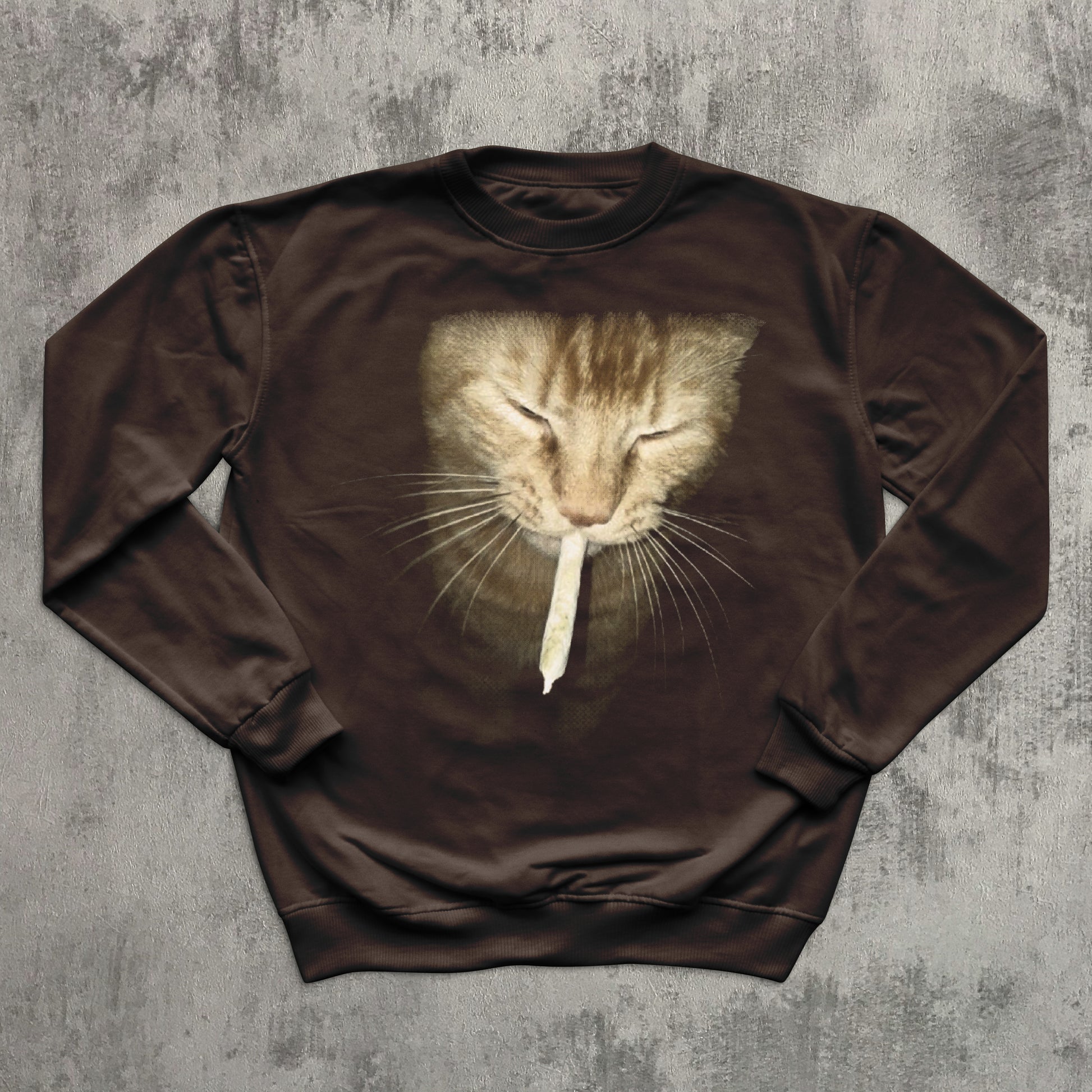 Brown sweatshirt with a cat graphic on a textured gray background