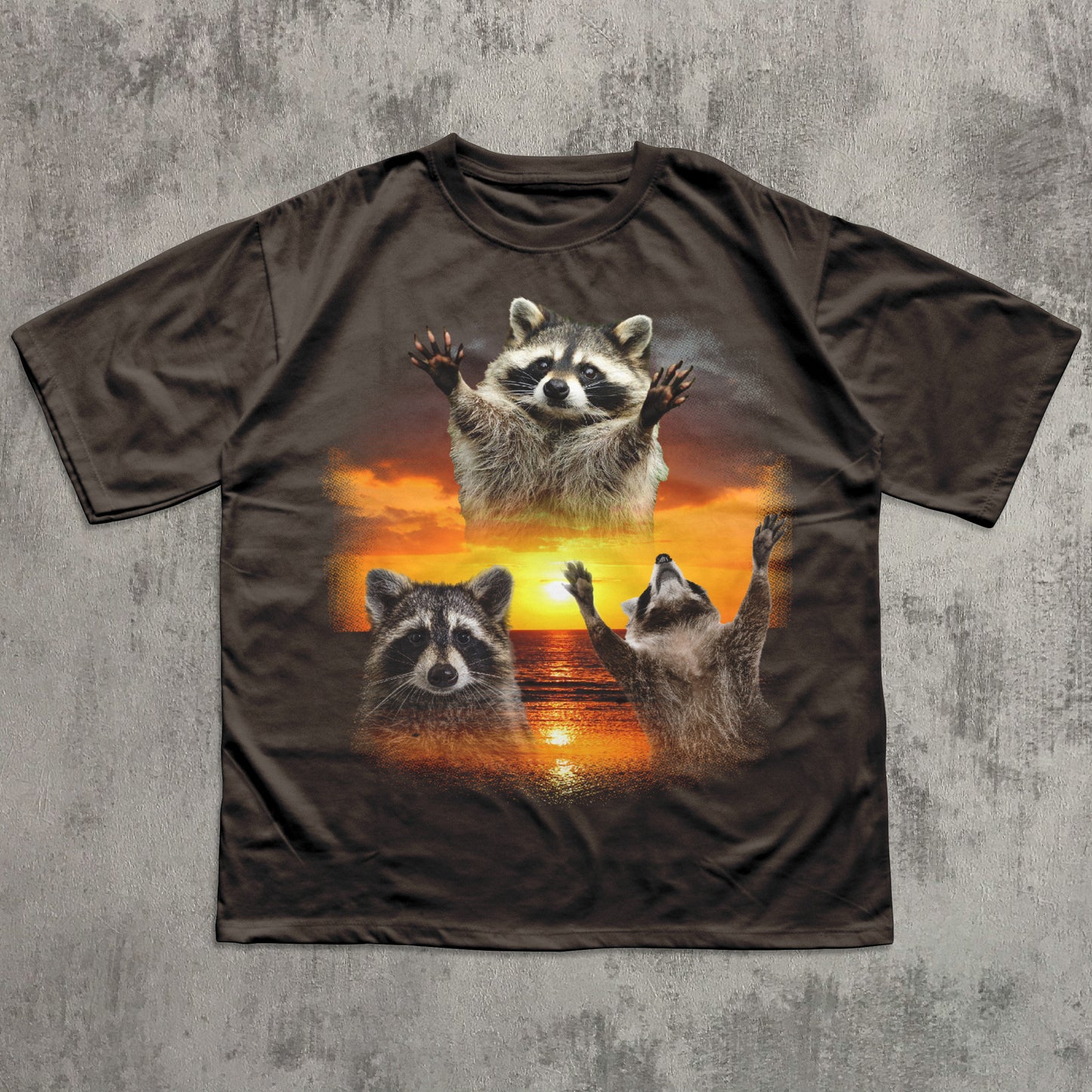 Brown t-shirt with raccoon design on a textured gray background
