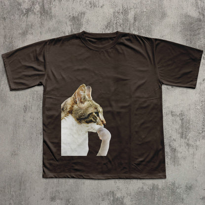 Brown t-shirt with a cat graphic on a textured gray background