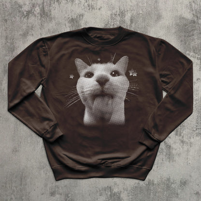 Brown sweatshirt with a cat graphic on a textured gray background