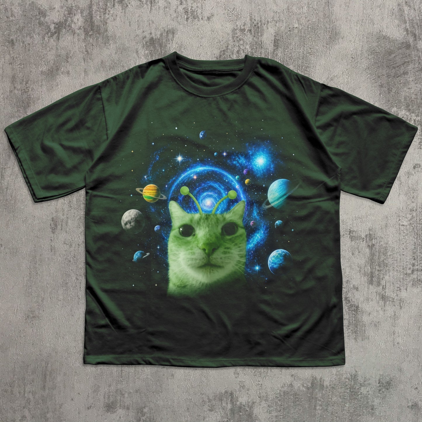 Green t-shirt with a cat in space design on a textured gray background