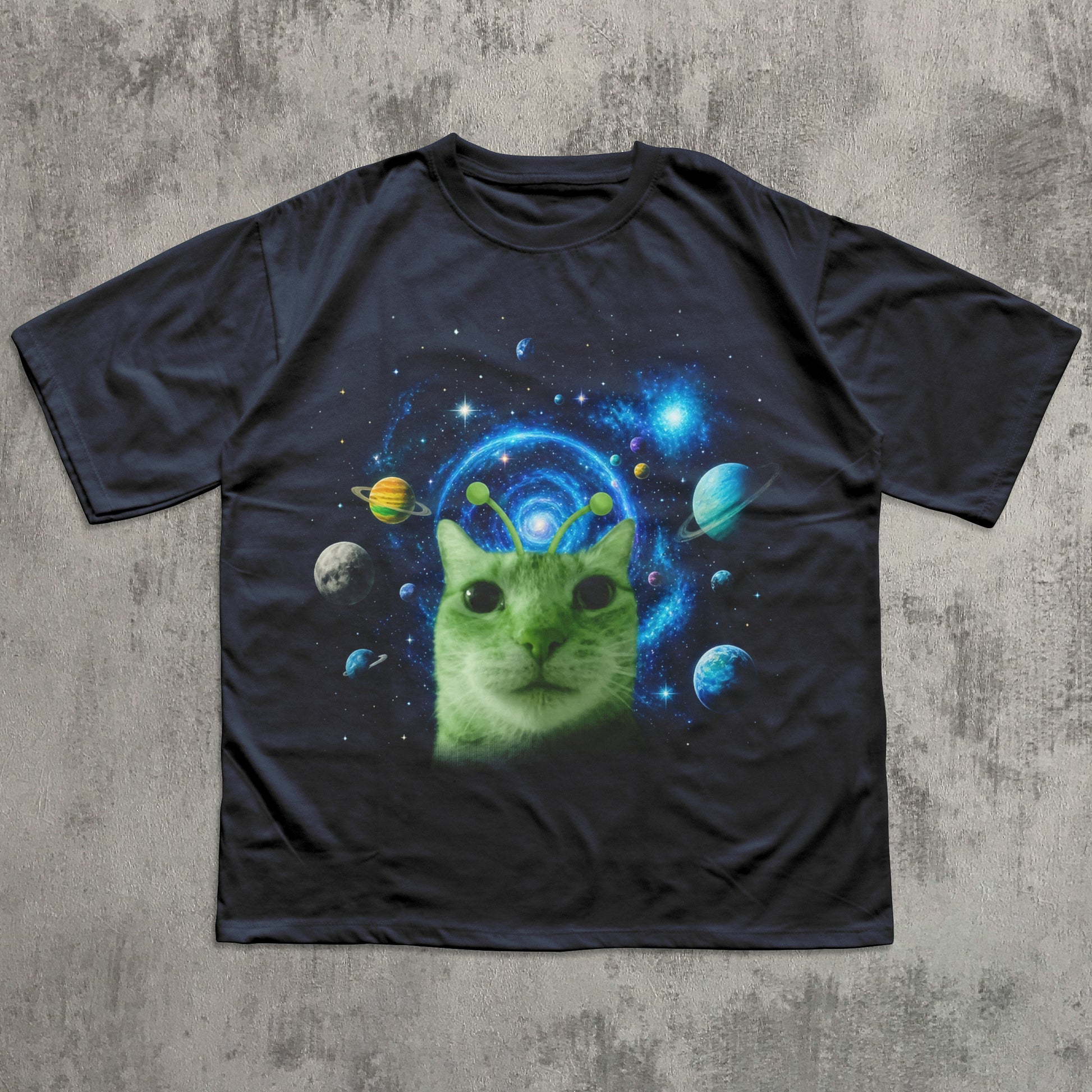 Black t-shirt with a green cat in space design on a textured gray background