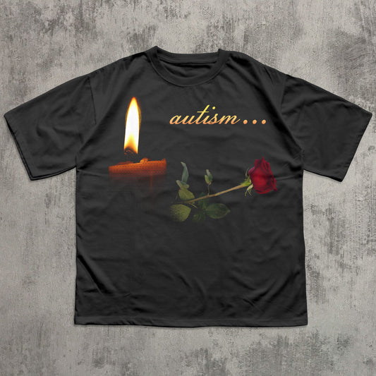 Black t-shirt with a candle and rose graphic and 'autism...' text on a textured gray background