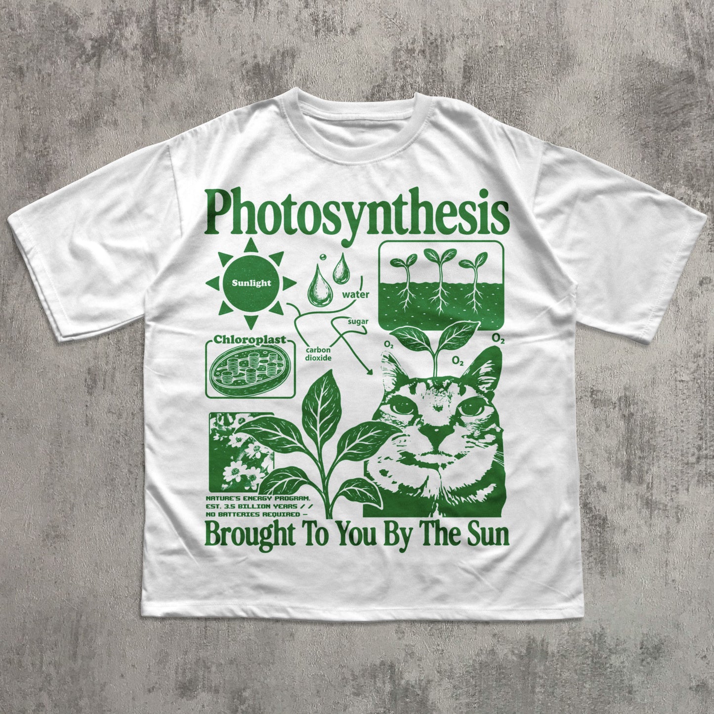 A white short-sleeve t-shirt with a green graphic print titled 'Photosynthesis' featuring a cat illustration and educational diagrams, laid flat on a textured gray background.