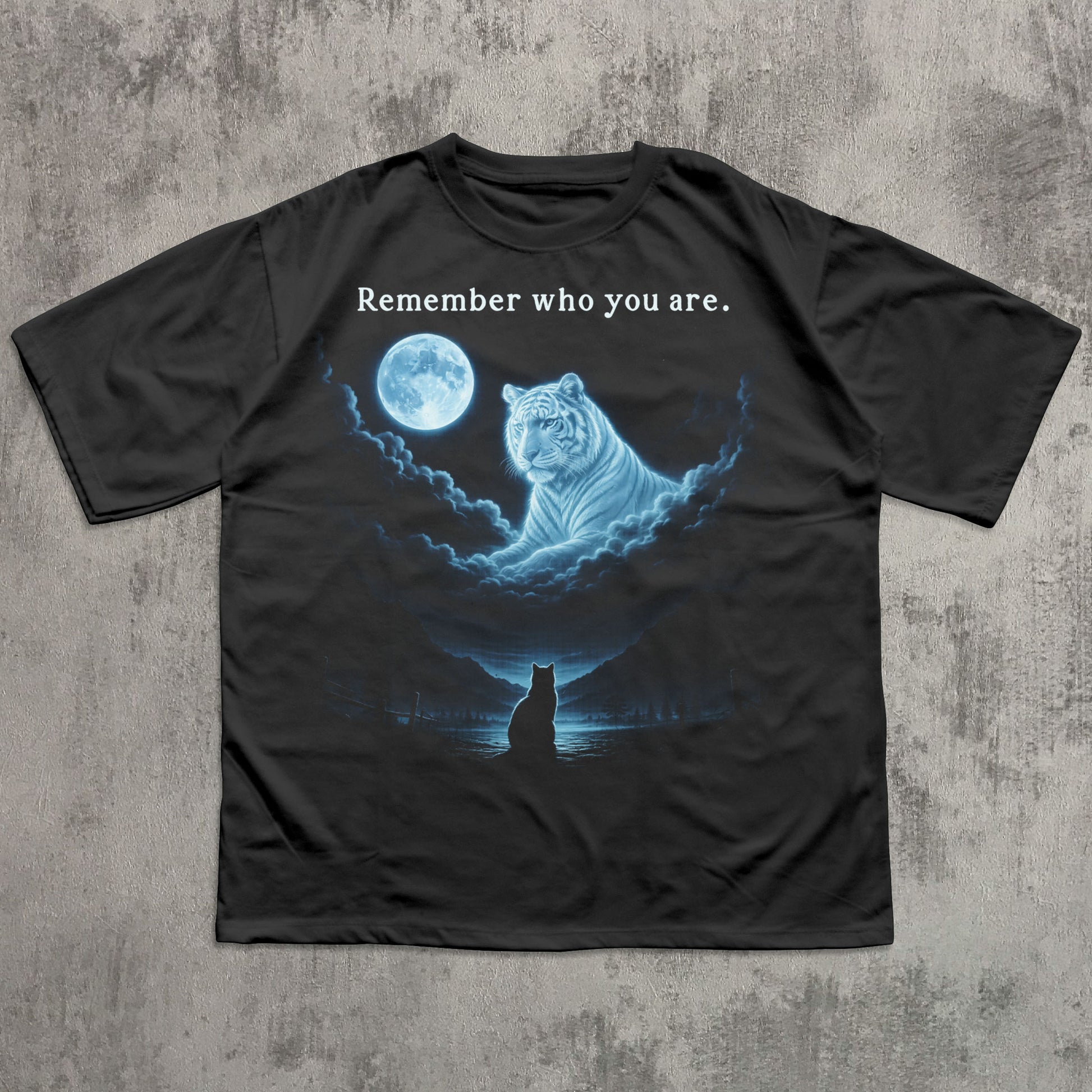Black t-shirt with a graphic of a tiger and moon, and text 'Remember who you are.' on a textured gray background.