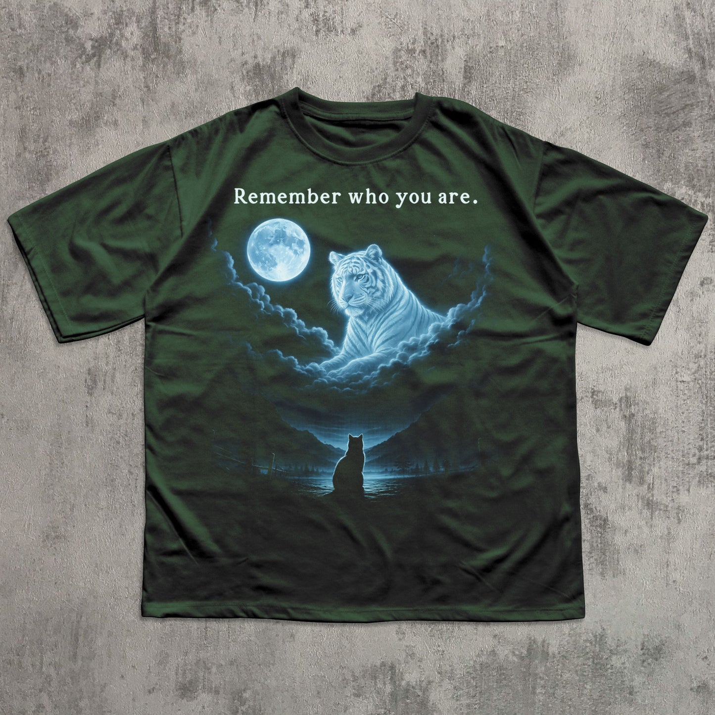 Green t-shirt with a graphic of a tiger and moon, and text 'Remember who you are.' on a textured gray background.