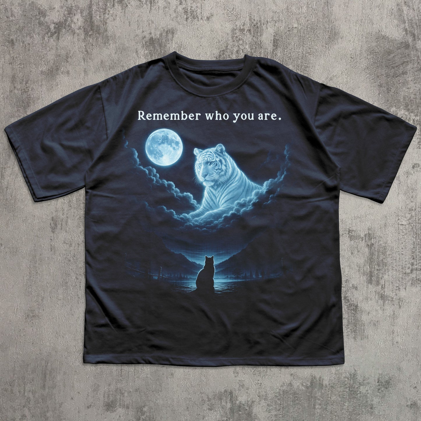 Black t-shirt with a graphic of a tiger and moon, and text 'Remember who you are.' on a textured gray background.
