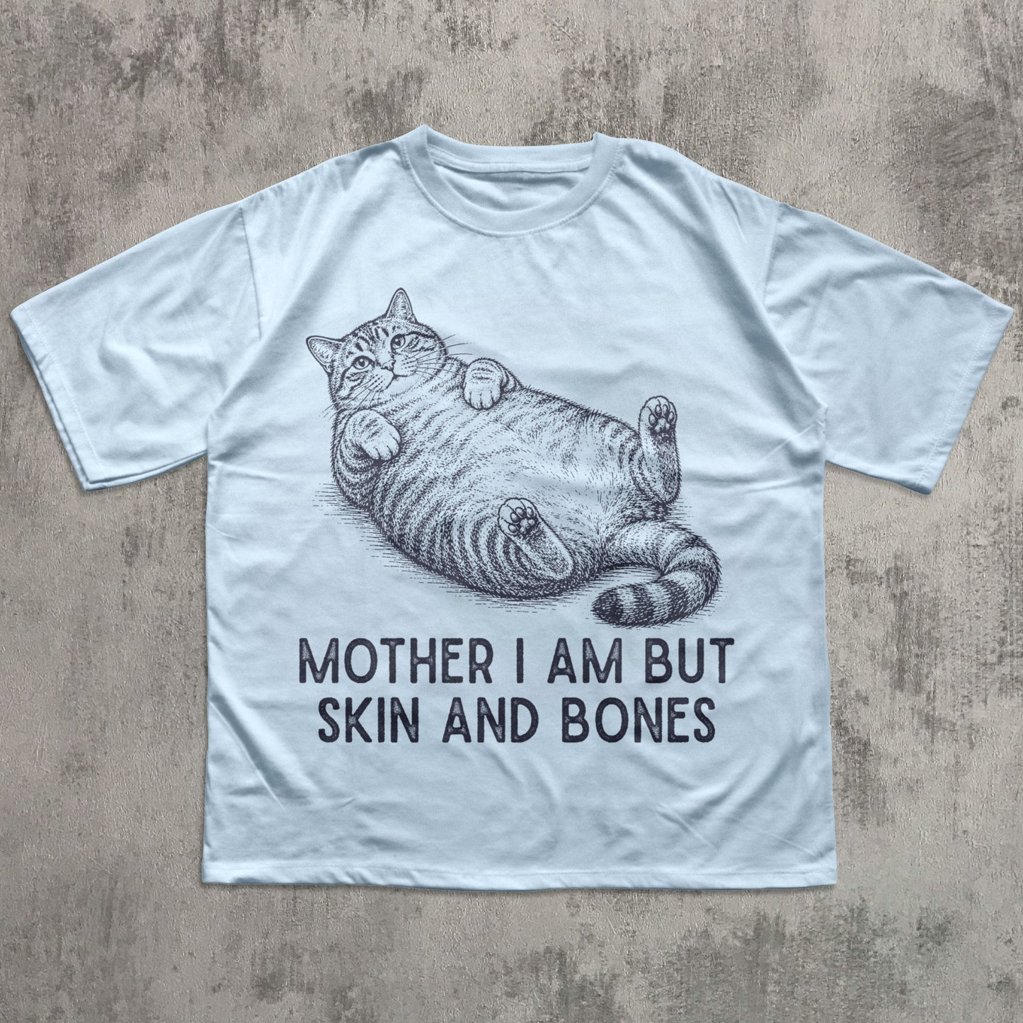 White t-shirt with a cat graphic and text on a textured surface