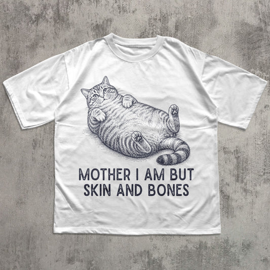 White t-shirt with a cat illustration and text on a concrete surface