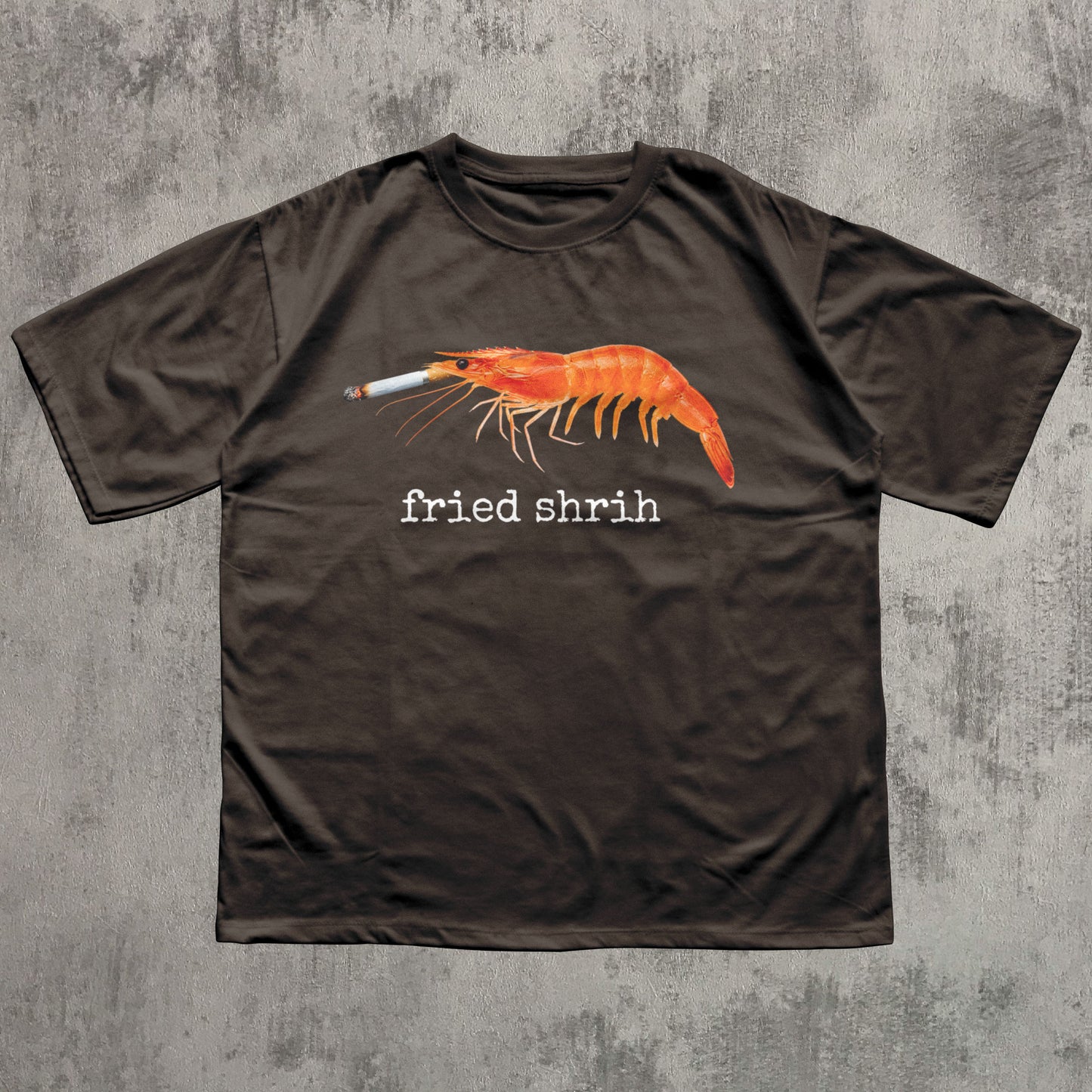 Brown t-shirt with a shrimp smoking a cigarette graphic and 'fried shrim' text on a textured gray background
