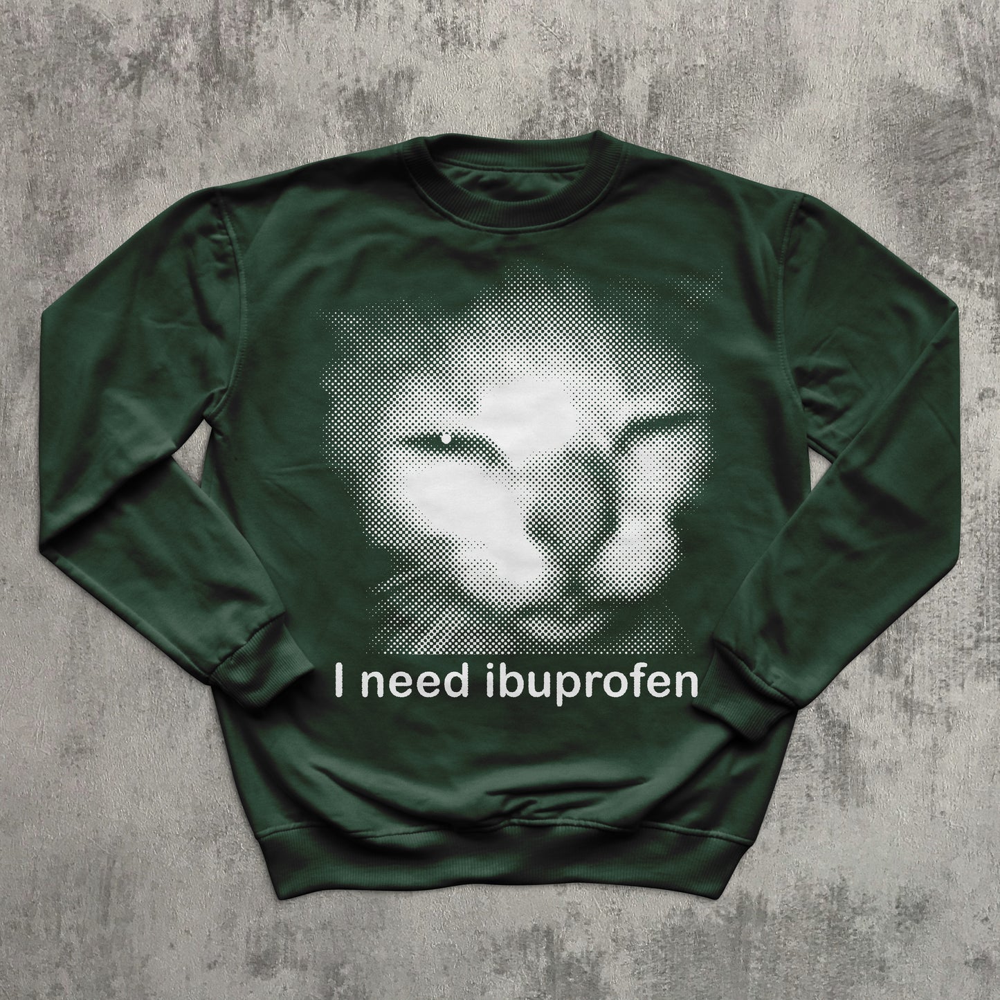 Unisex green crewneck sweatshirt with halftone sad cat meme graphic and humorous slogan ‘I need ibuprofen,’ perfect for cat lovers and meme apparel