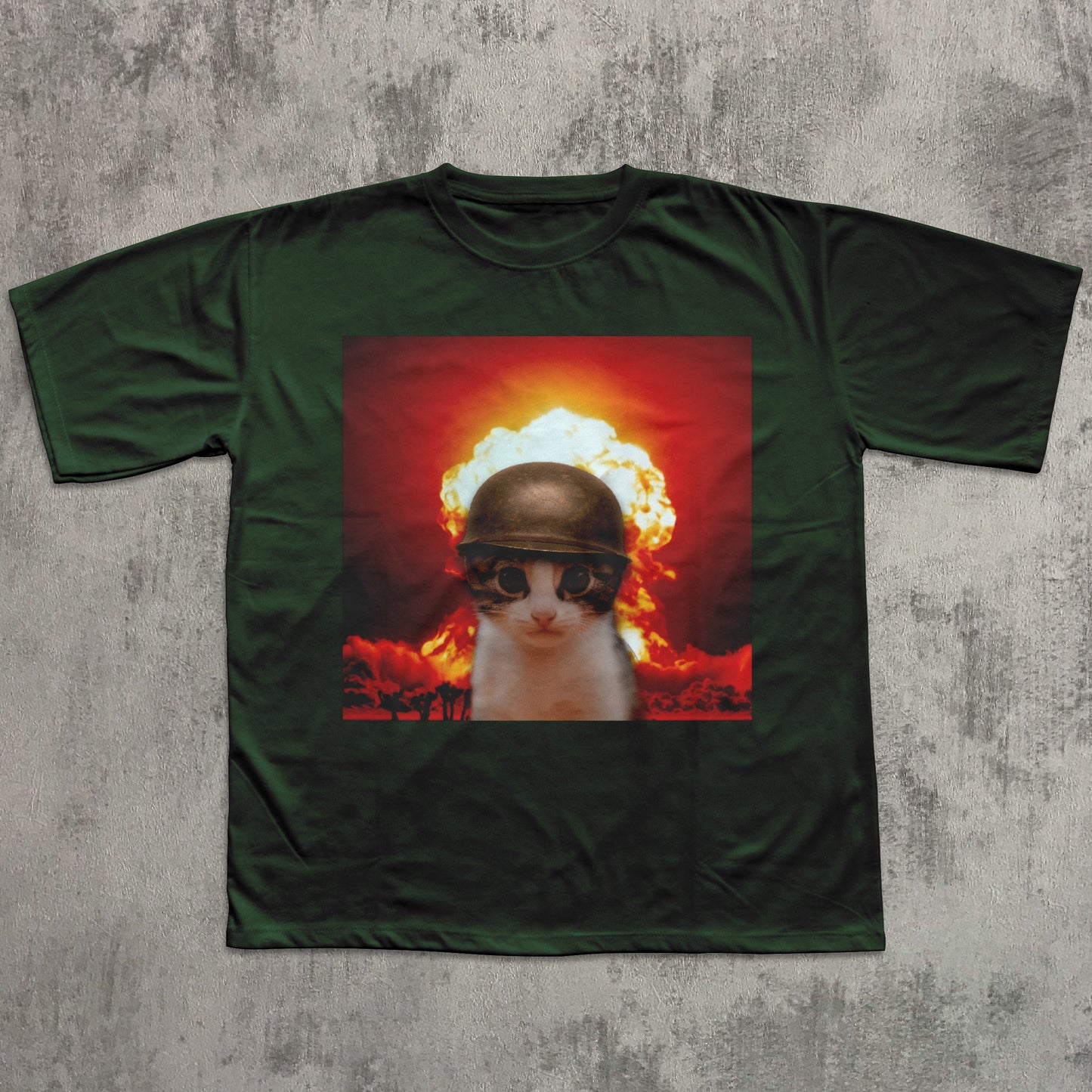 Green t-shirt with a graphic of a cat in a helmet amidst an explosion on a textured gray background