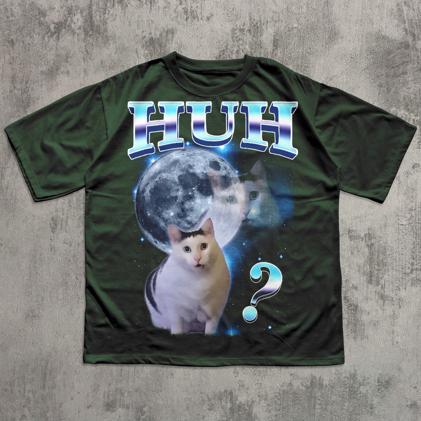 Green t-shirt with a cat graphic and 'HUH?' text on a textured gray background