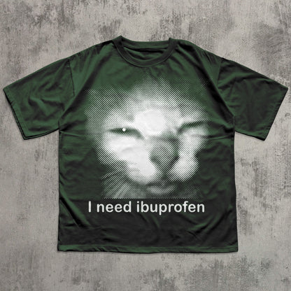 Green t-shirt with a graphic of a cat and text 'I need ibuprofen' on a textured gray background