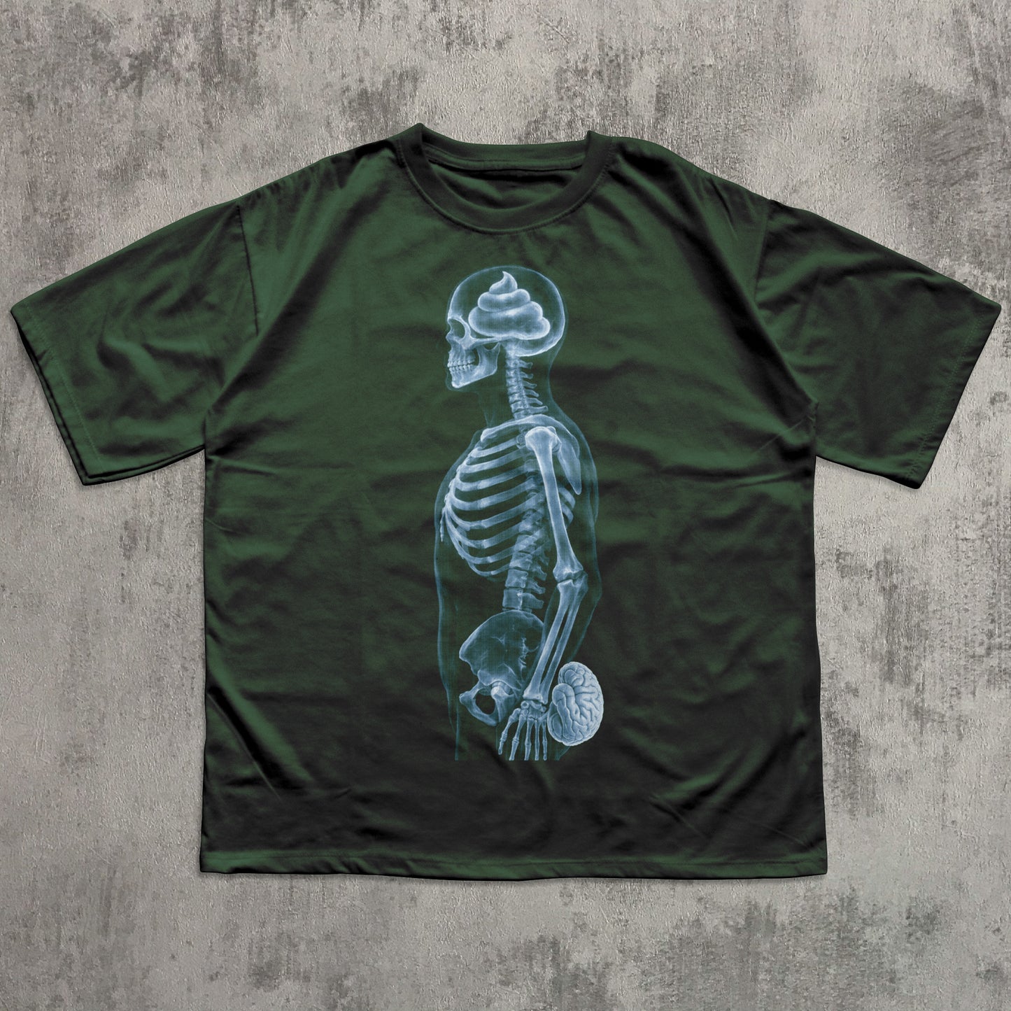 Humorous green graphic T-shirt featuring a blue X-ray skeleton with a poop-shaped brain in the skull and the brain held at the crotch, funny anatomy joke shirt