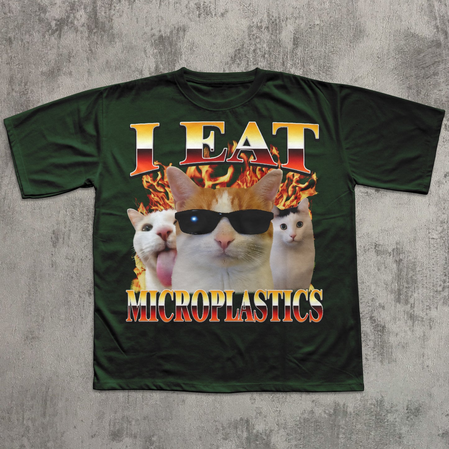 Green t-shirt with a graphic of a cat wearing sunglasses and text 'I Eat Microplastics' on a concrete background