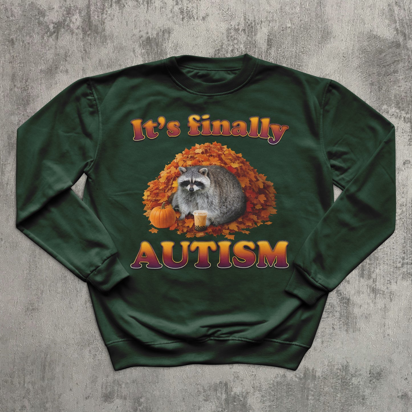 Green sweatshirt with raccoon and autumn design on a textured gray background