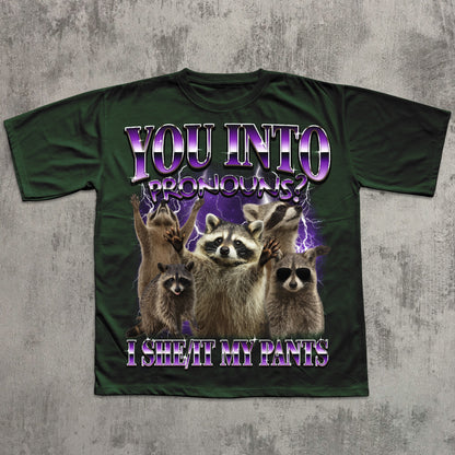 Green t-shirt with raccoon graphic and humorous text on a textured gray background