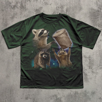 Green funny t-shirt with raccoon design on a textured gray background
