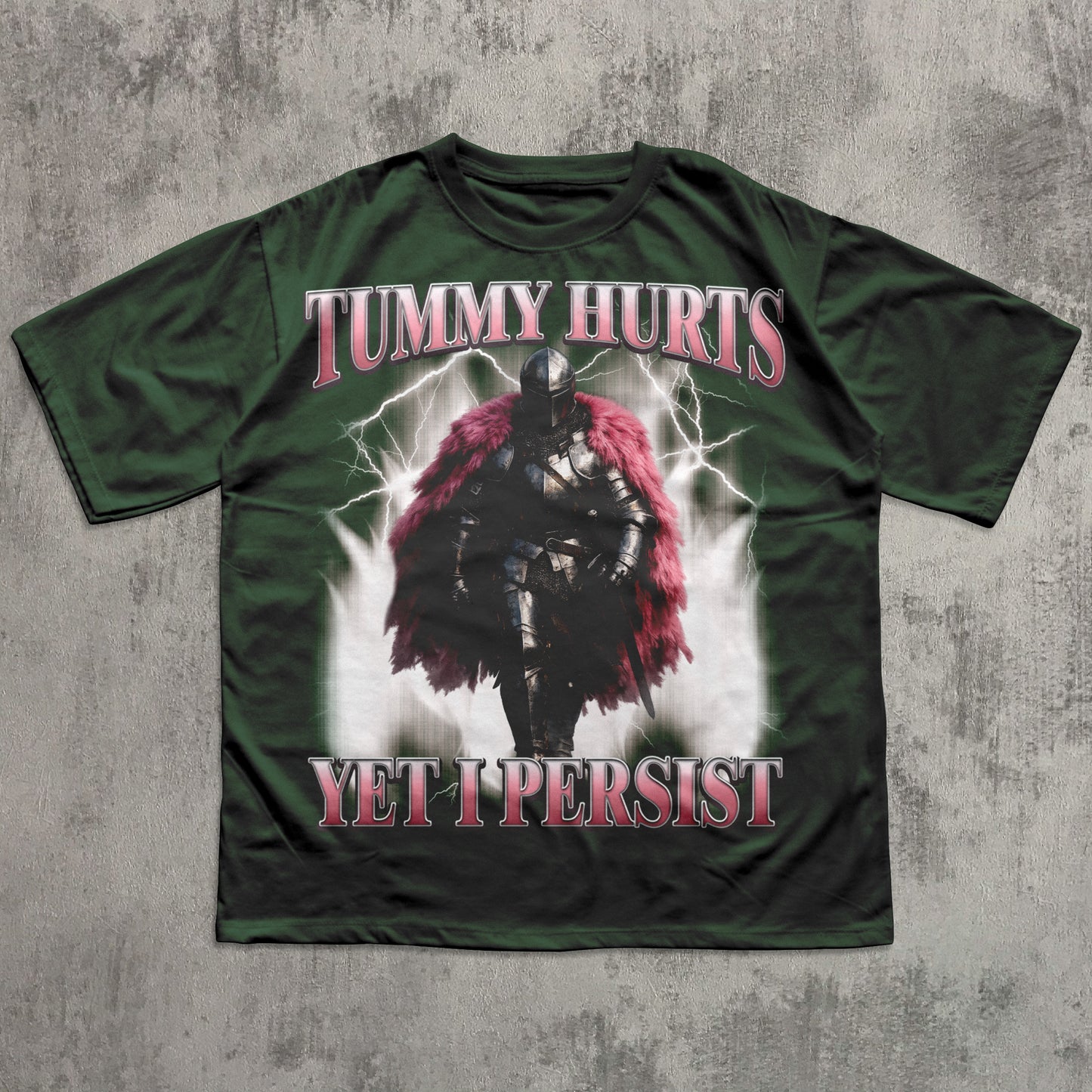 Green t-shirt with warrior graphic and text 'Tummy Hurts Yet I Persist' on a textured gray background