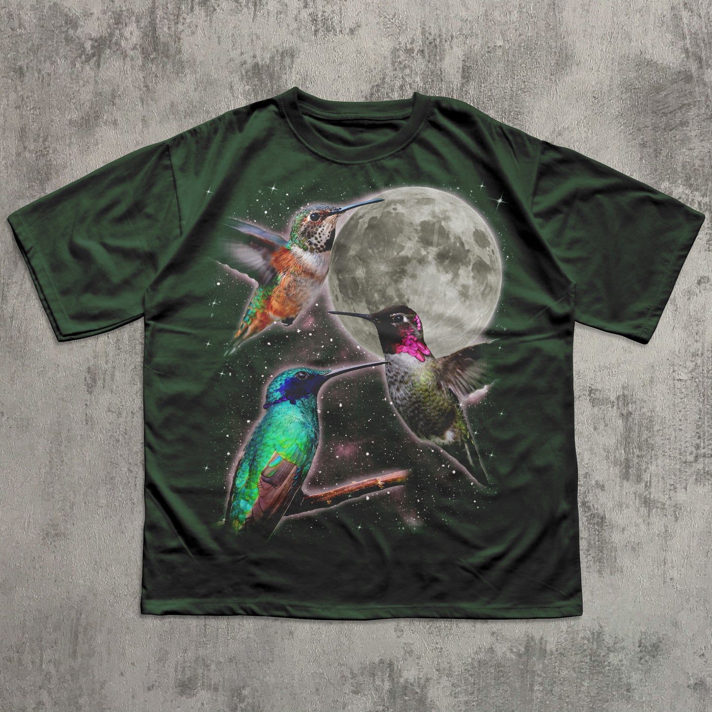 Green t-shirt with colorful hummingbird design and moon on a textured gray background