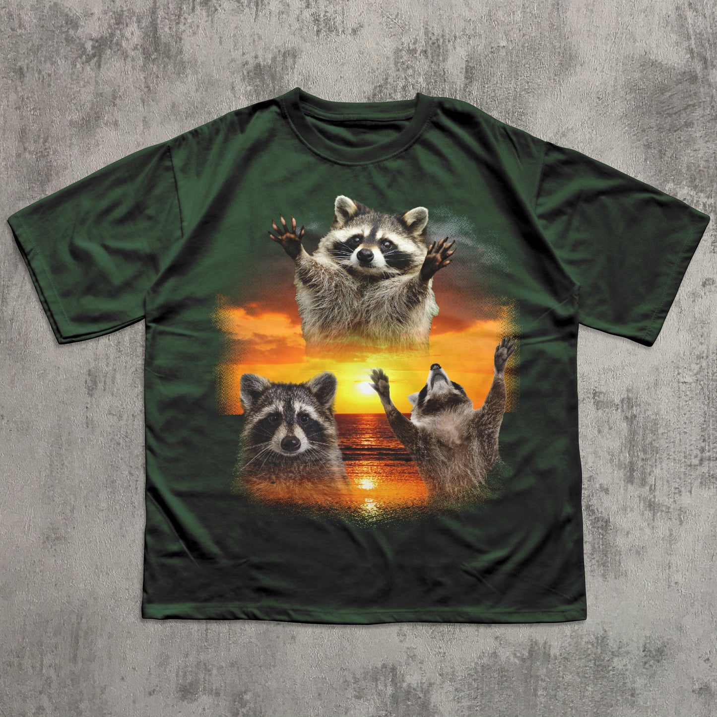 Green t-shirt with raccoon design on a textured gray background