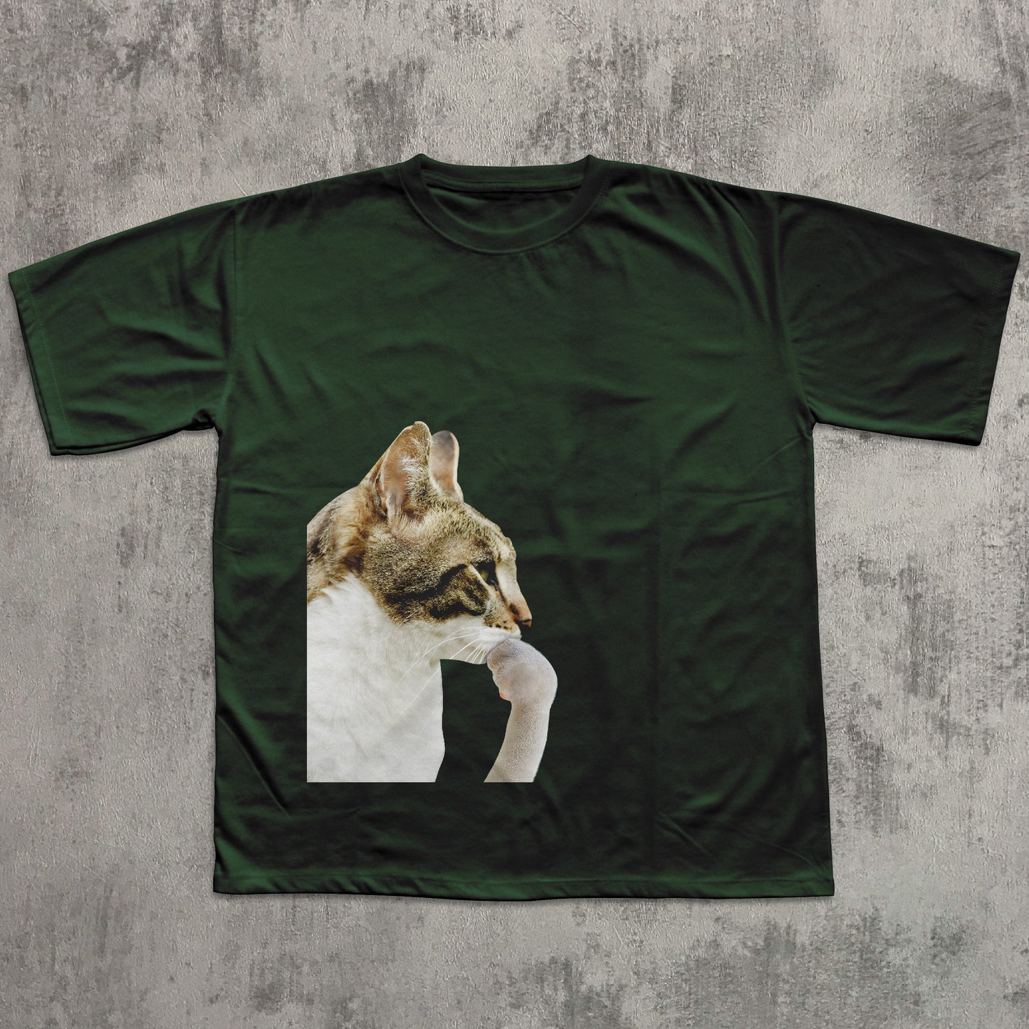 Green t-shirt with a cat graphic on a textured gray background
