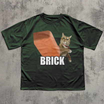Green t-shirt with a cat graphic and 'BRICK' text on a textured gray background