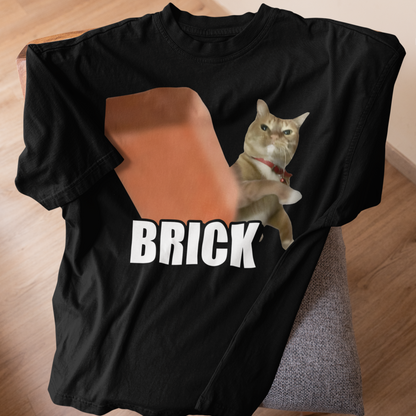 Black t-shirt with a cat graphic and 'BRICK' text on a wooden surface