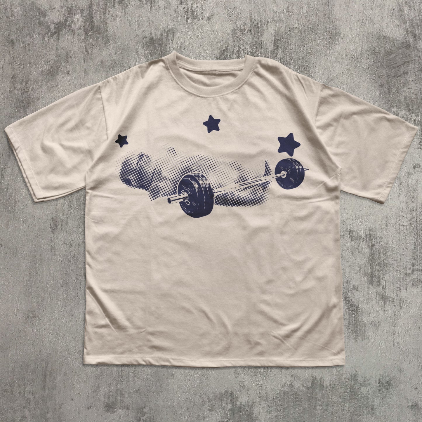 Beige t-shirt with a graphic of a barbell and weights on a textured gray background