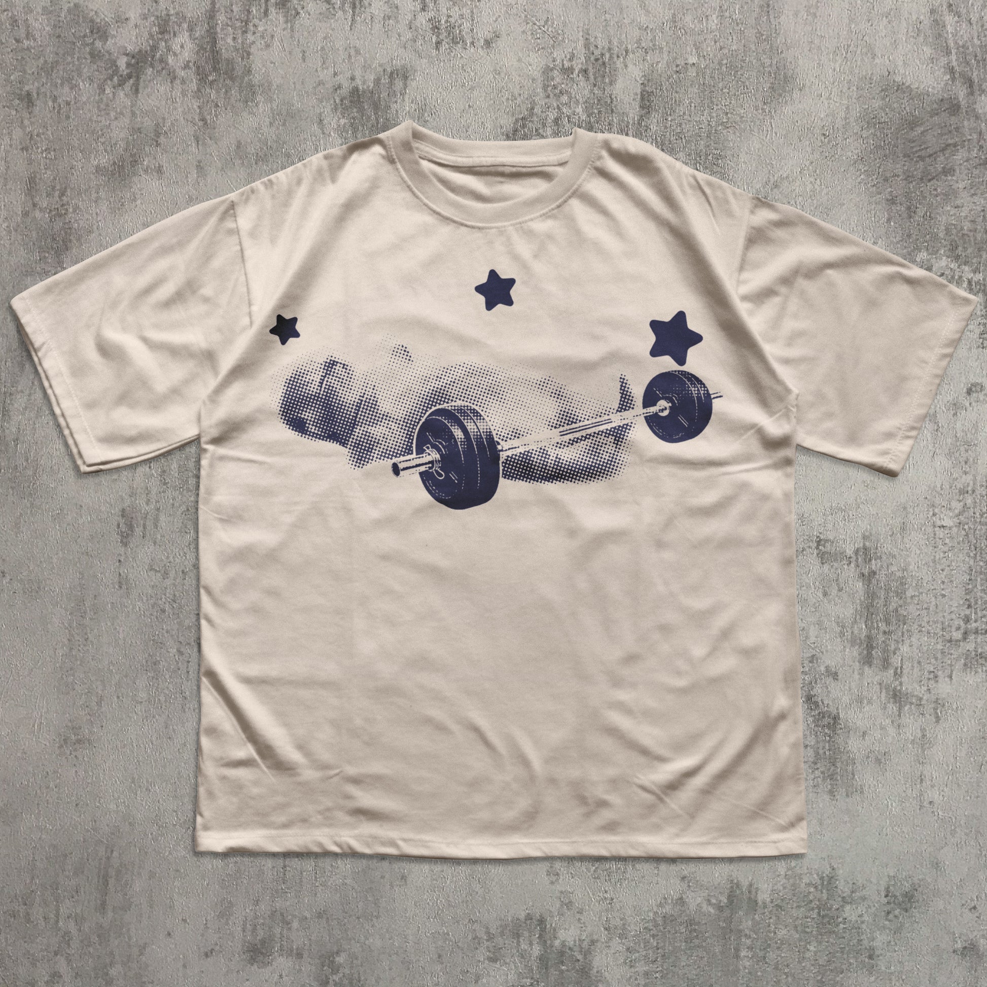 Beige t-shirt with a graphic of a barbell and weights on a textured gray background
