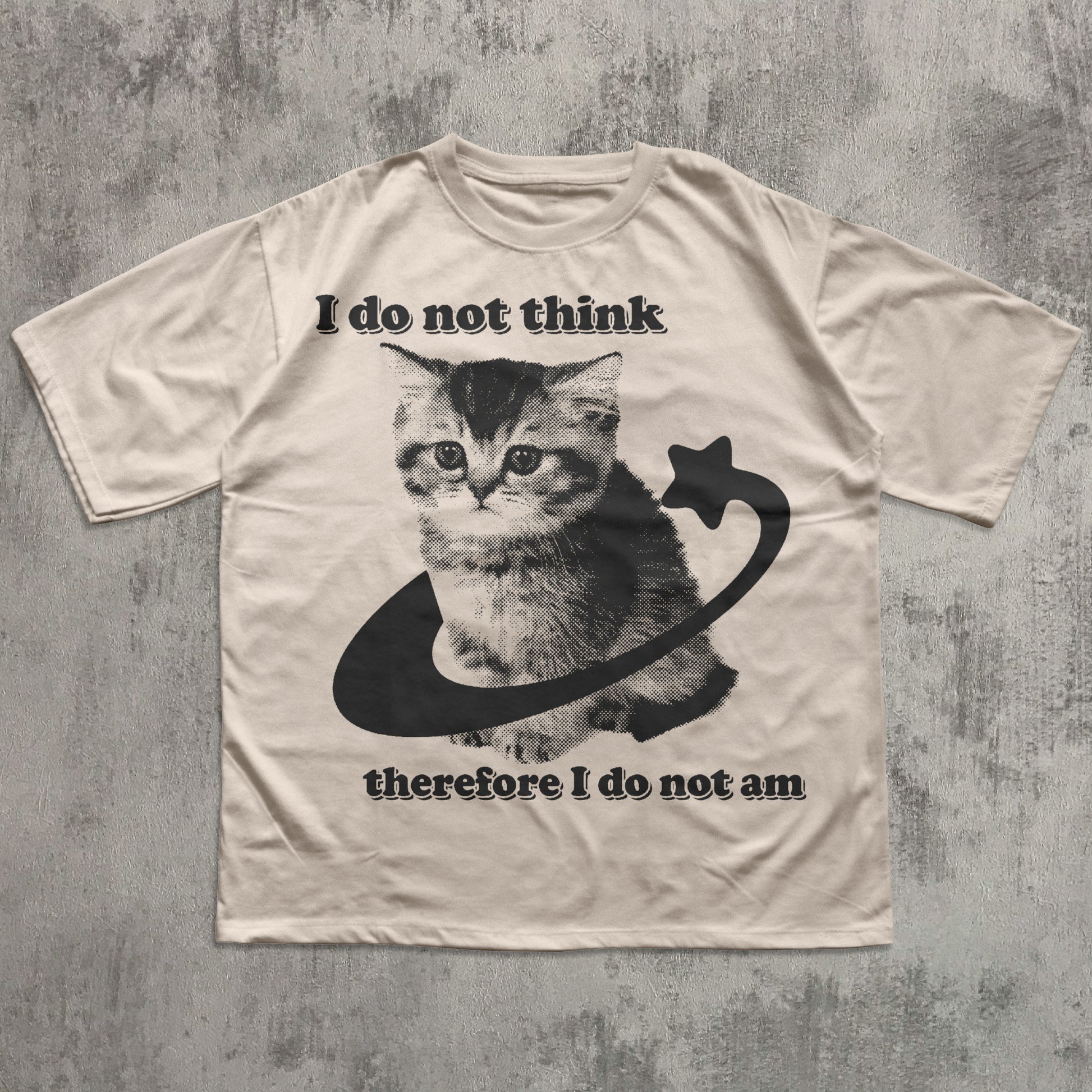 Beige t-shirt with a cat graphic and philosophical text on a textured gray background