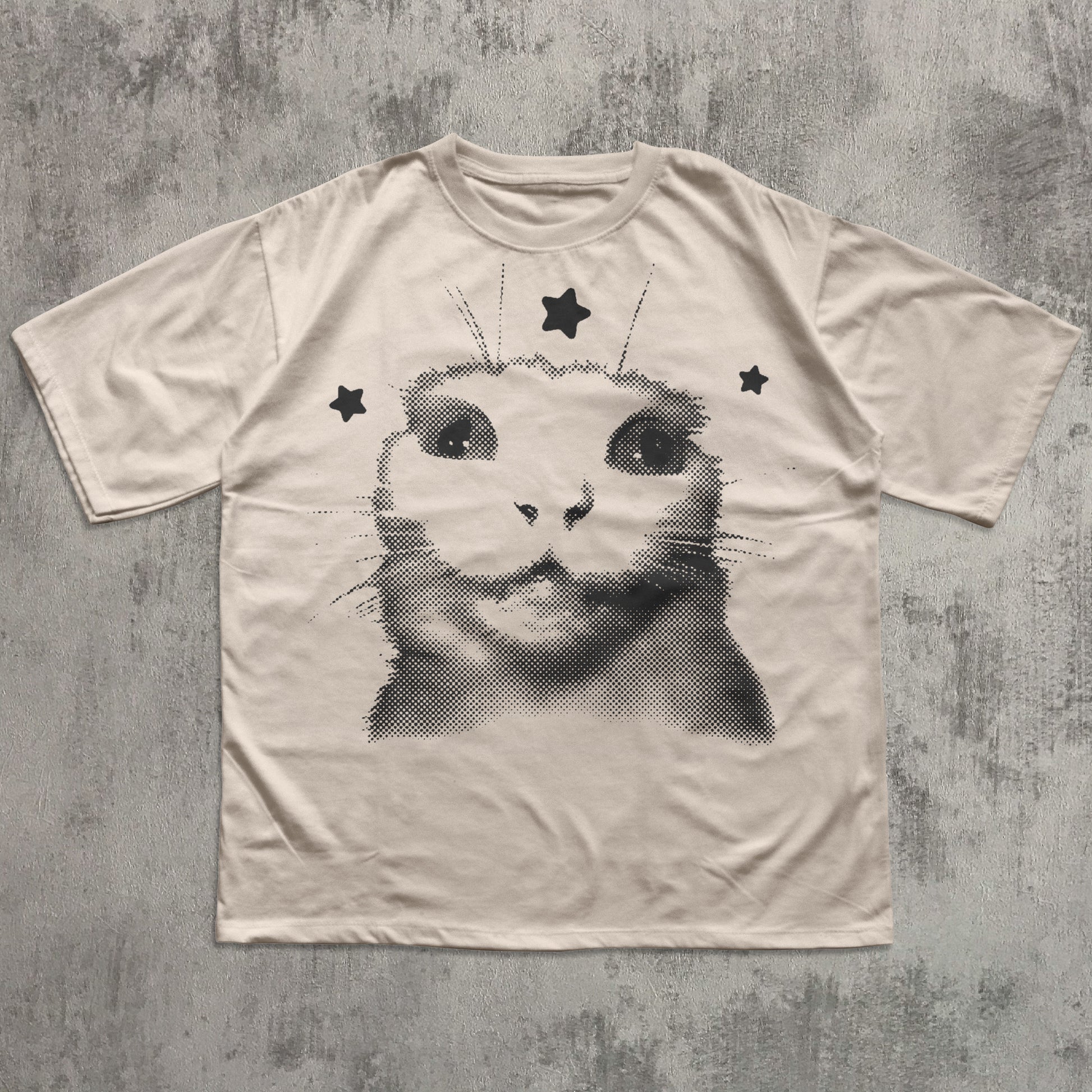 T-shirt with a cat graphic design on a textured gray background