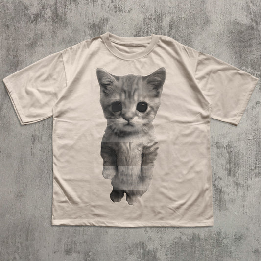 Beige t-shirt with a printed cat design on a textured gray background