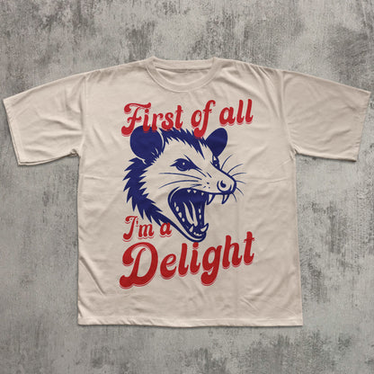 Beige t-shirt with a graphic of a possum and text on a textured gray background