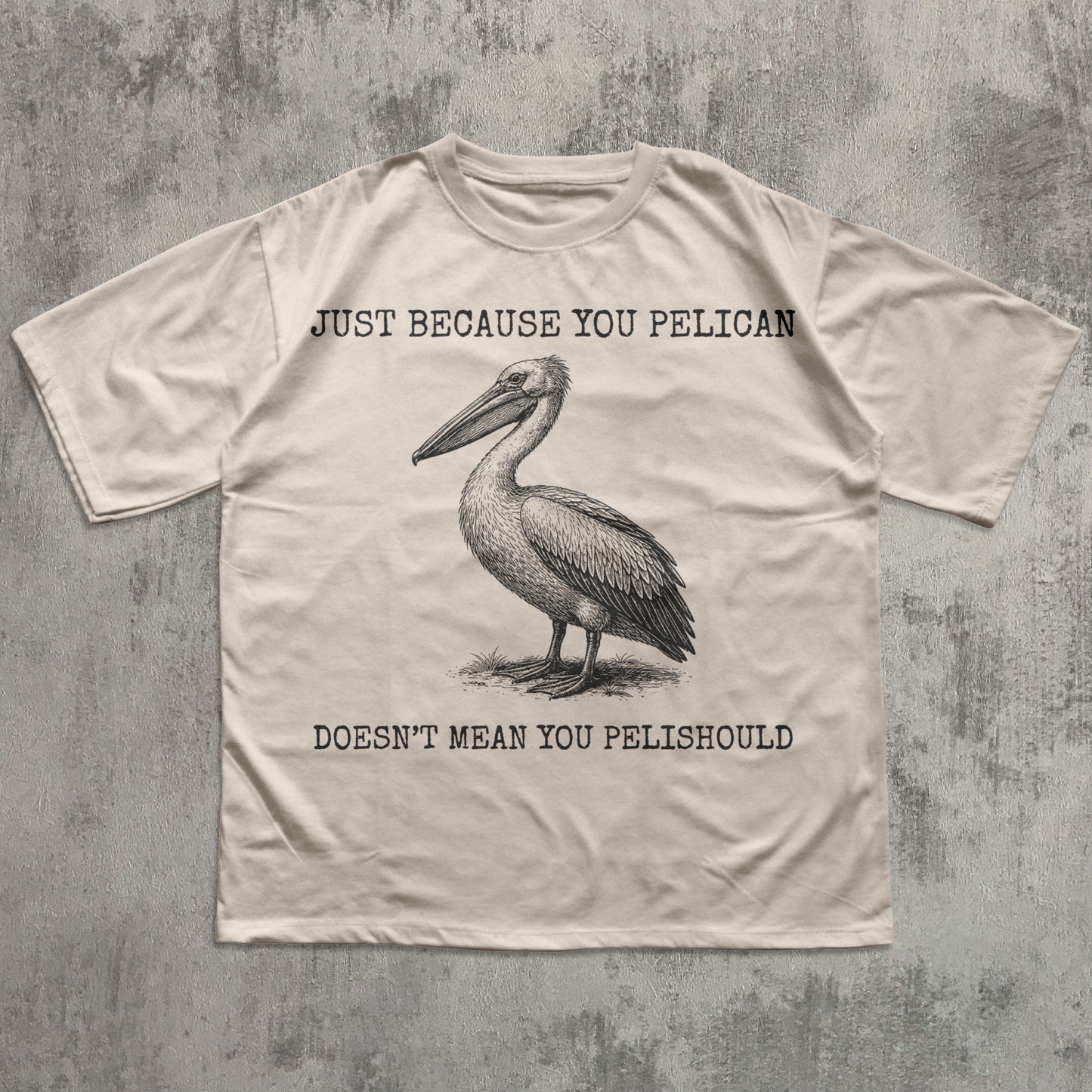 Beige t-shirt with a pelican graphic and humorous text on a textured gray background