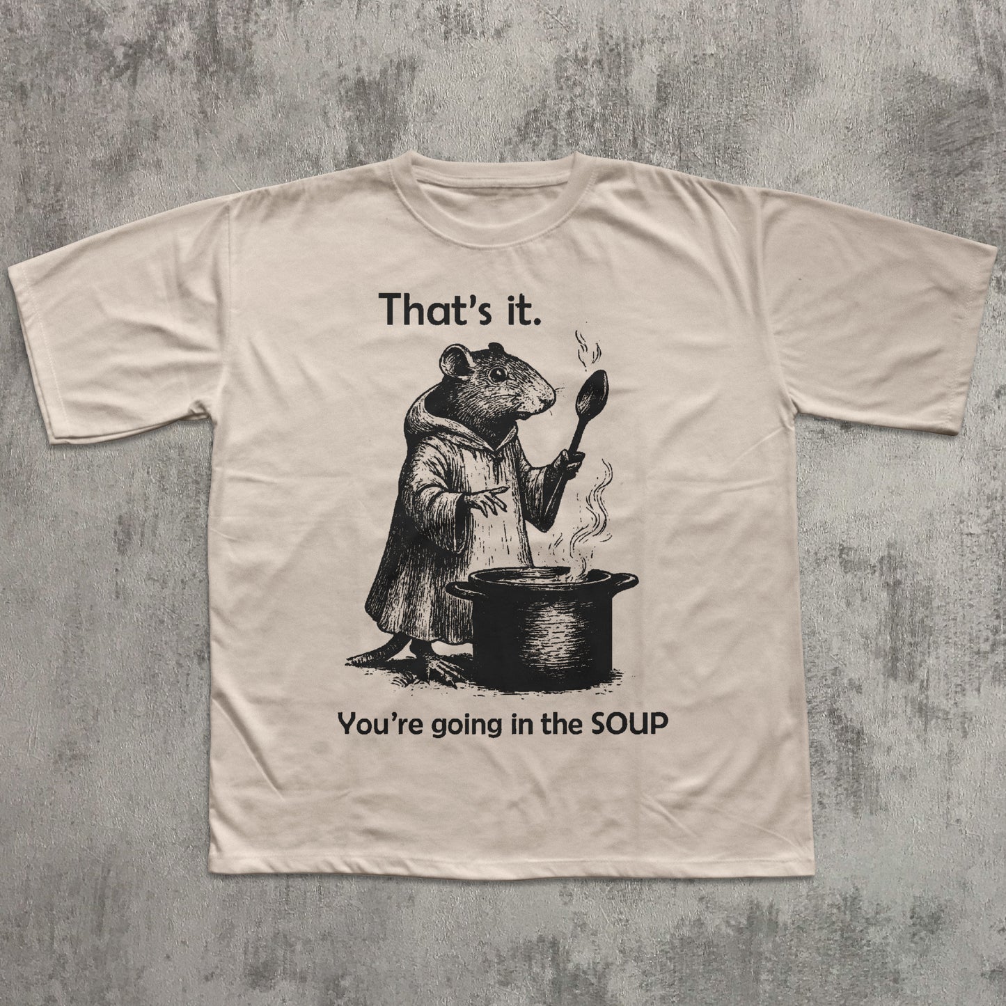 Beige t-shirt with a graphic of a rat and text on a textured gray background