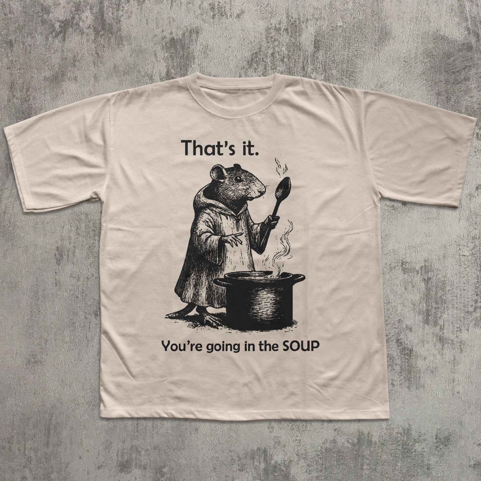 Beige t-shirt with a graphic of a rat and text on a textured gray background