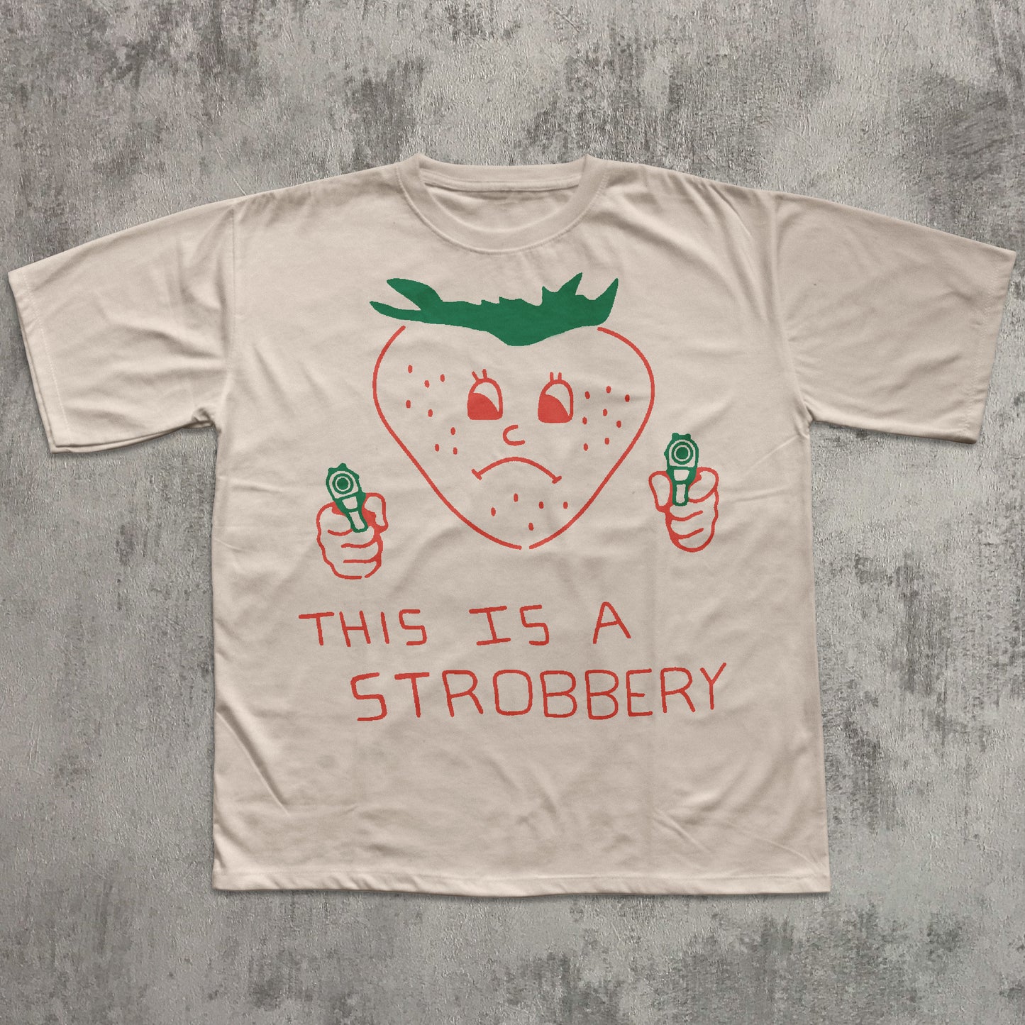 Beige t-shirt with a strawberry graphic and text on a textured gray background