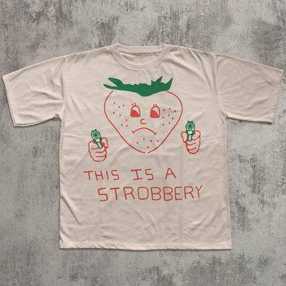 Beige t-shirt with a strawberry graphic and text on a textured gray background