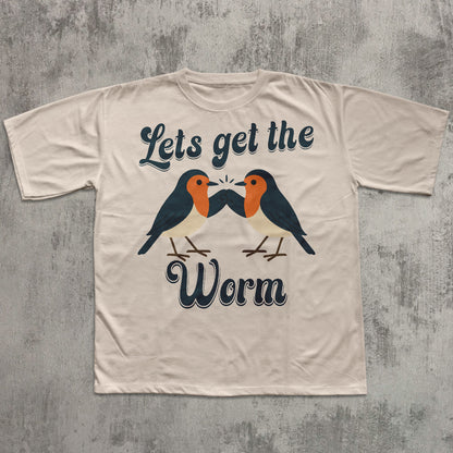 Beige t-shirt with birds graphic and text 'Let's get the Worm' on a textured gray background
