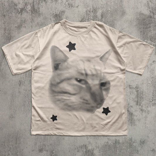 T-shirt with a cat face design and star shapes on a textured gray background