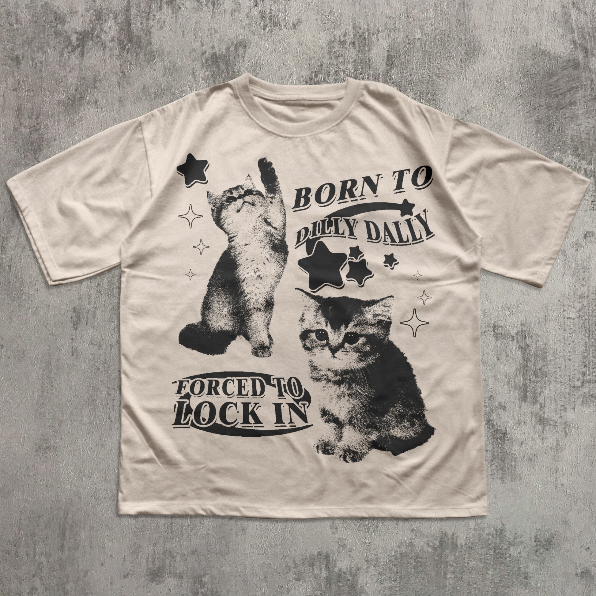 Beige t-shirt with black cat graphics and text on a textured gray background