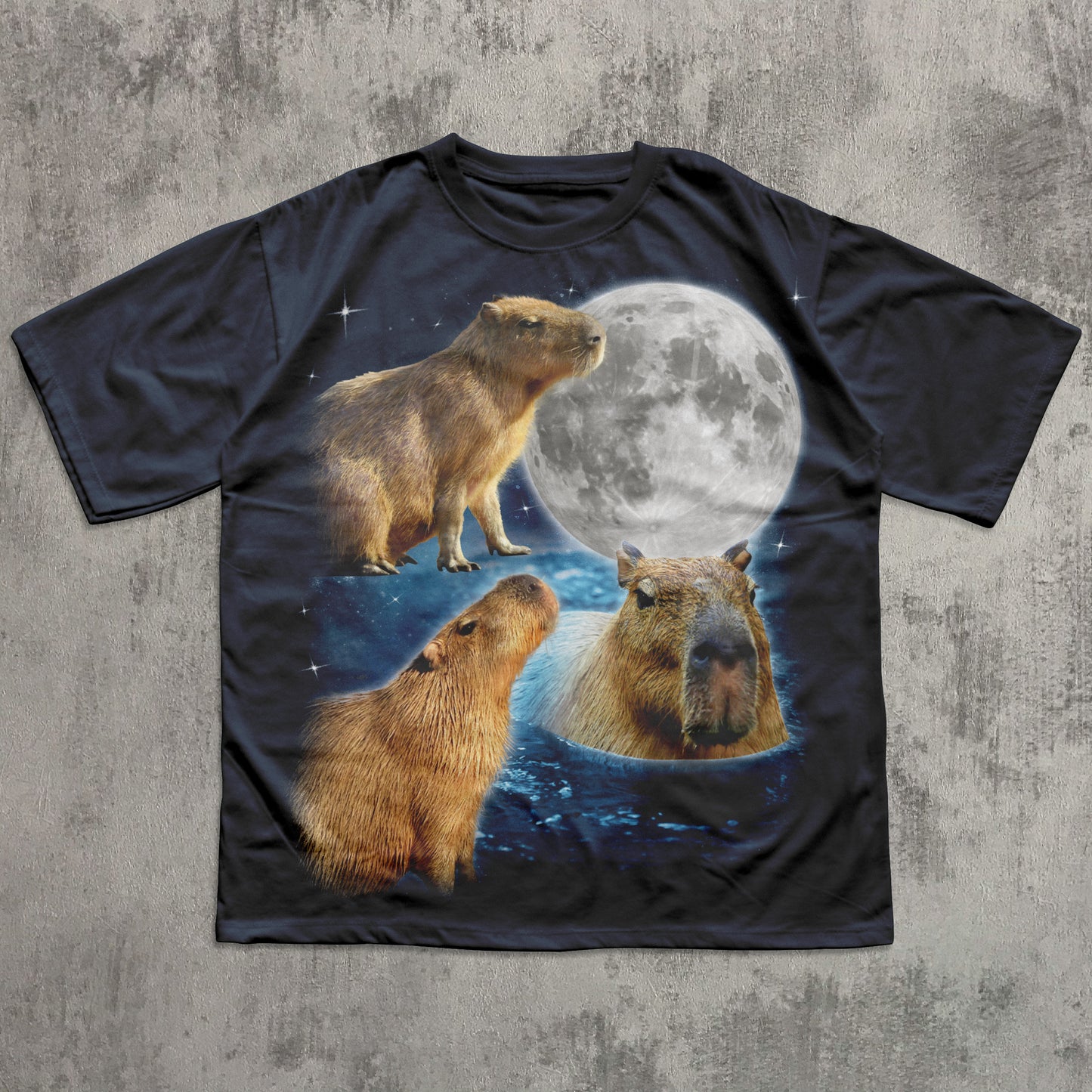 Black t-shirt with capybara design and moon on a textured gray background