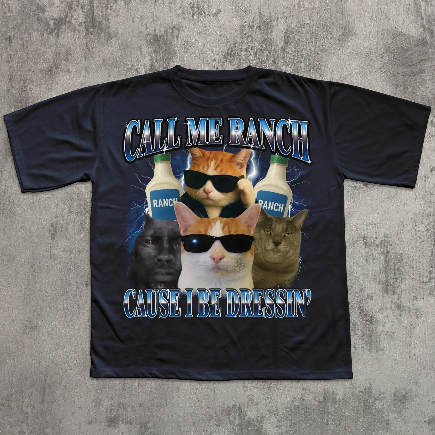 Black t-shirt with graphic design of cats wearing sunglasses and Ranch dressing bottles on a concrete surface.